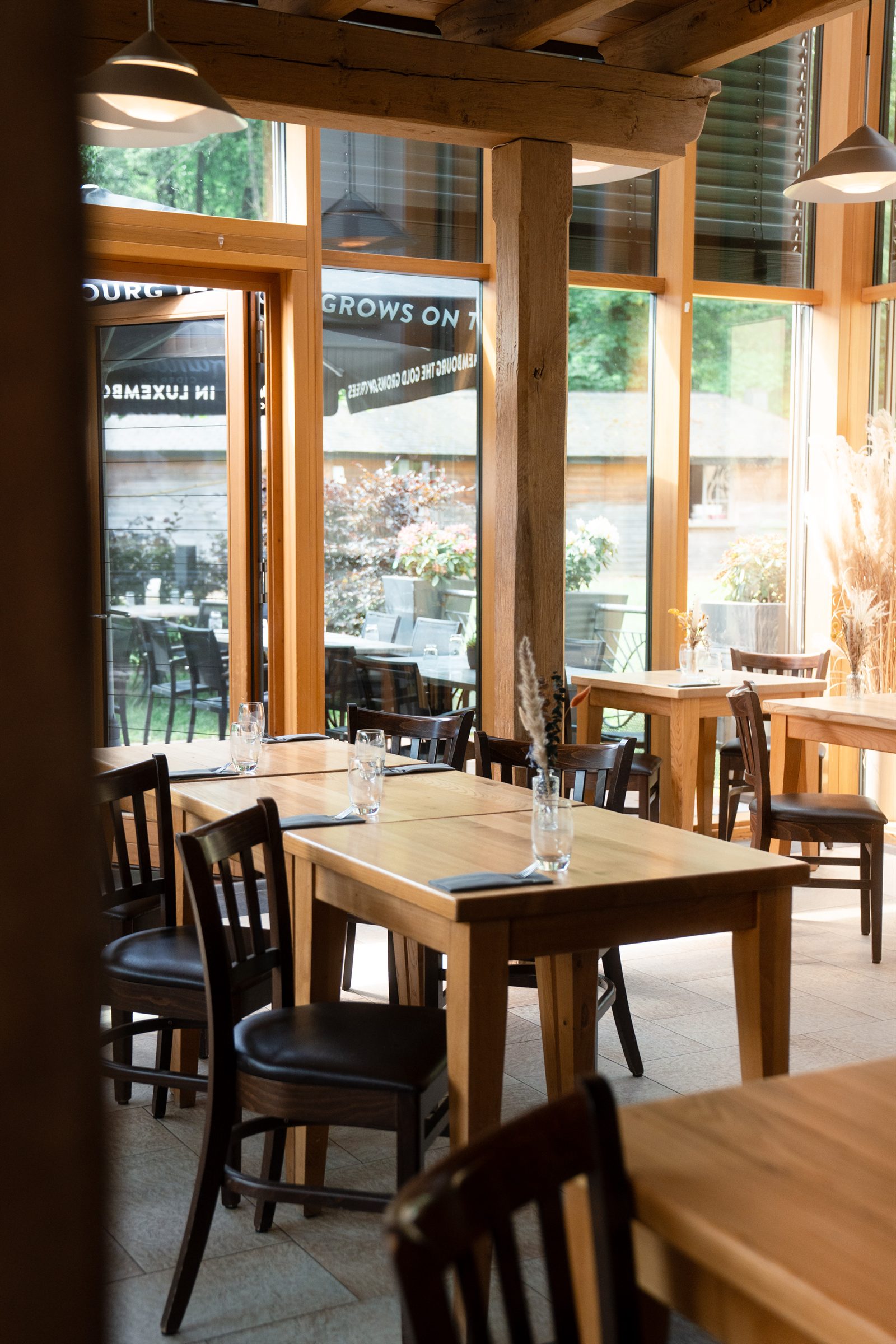 The oak-and-glass dining room of Heringer Millen, looking out to the forest