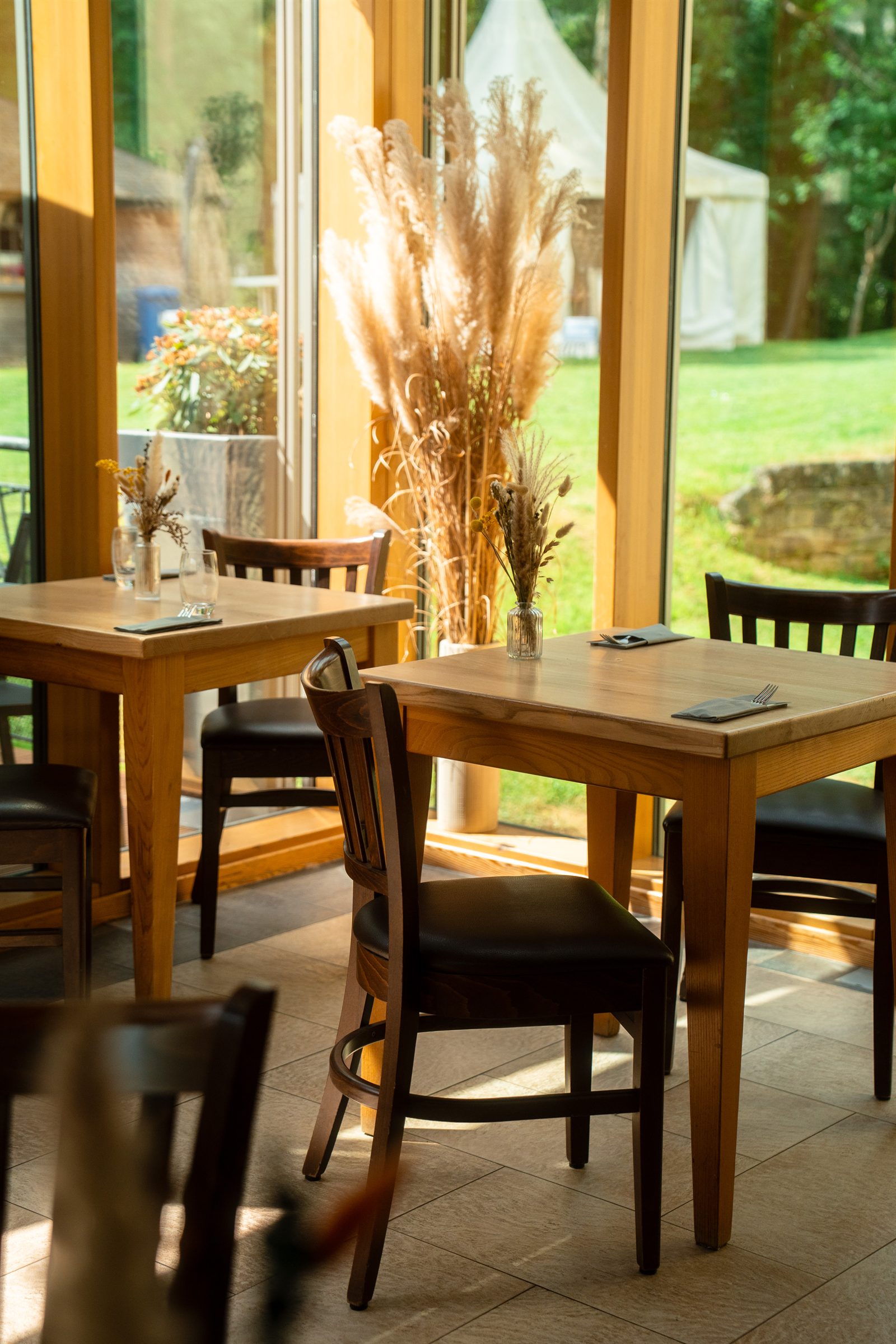 Sunlit tables by the windows looking onto the forest