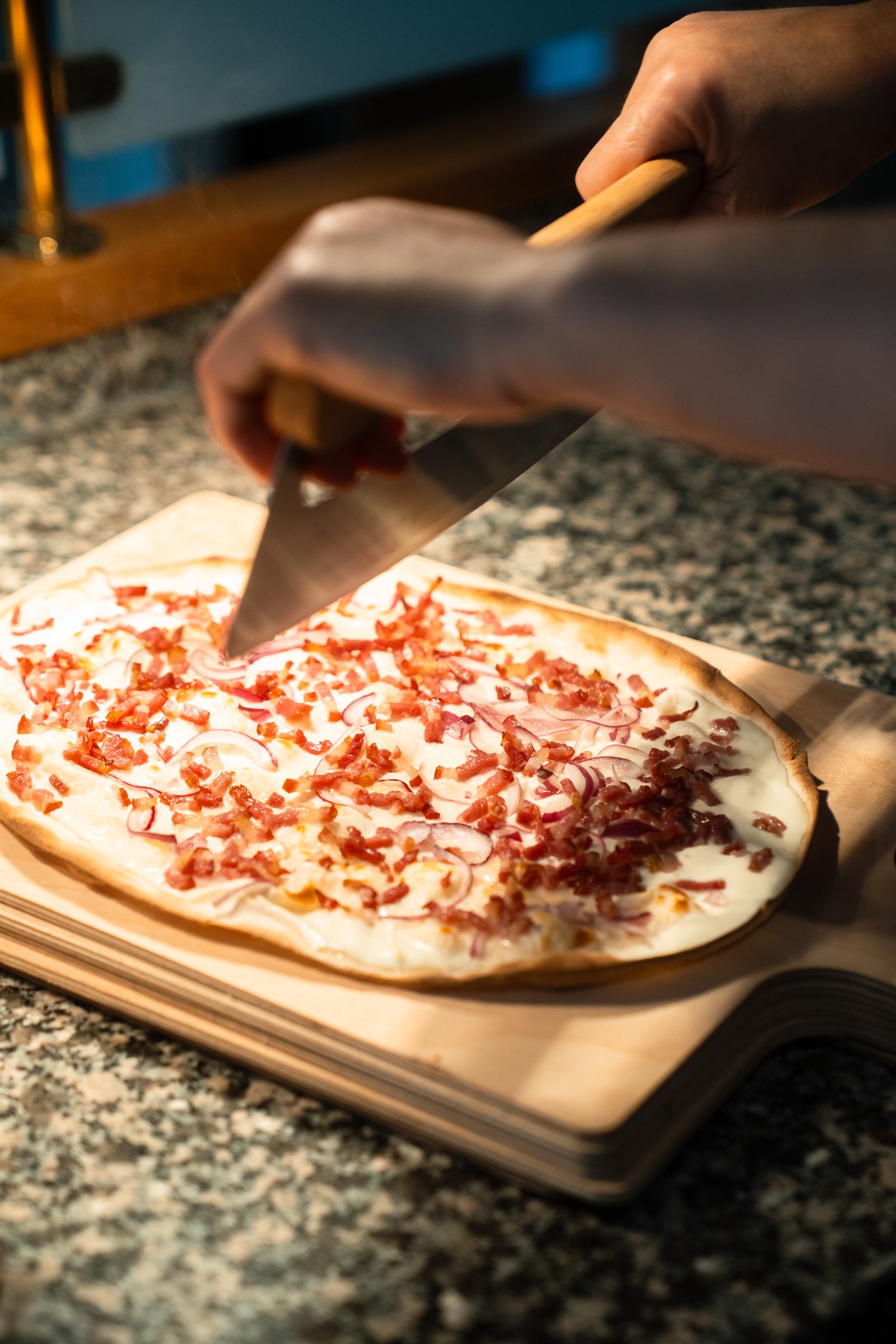 A chef slicing fresh flammkuchen