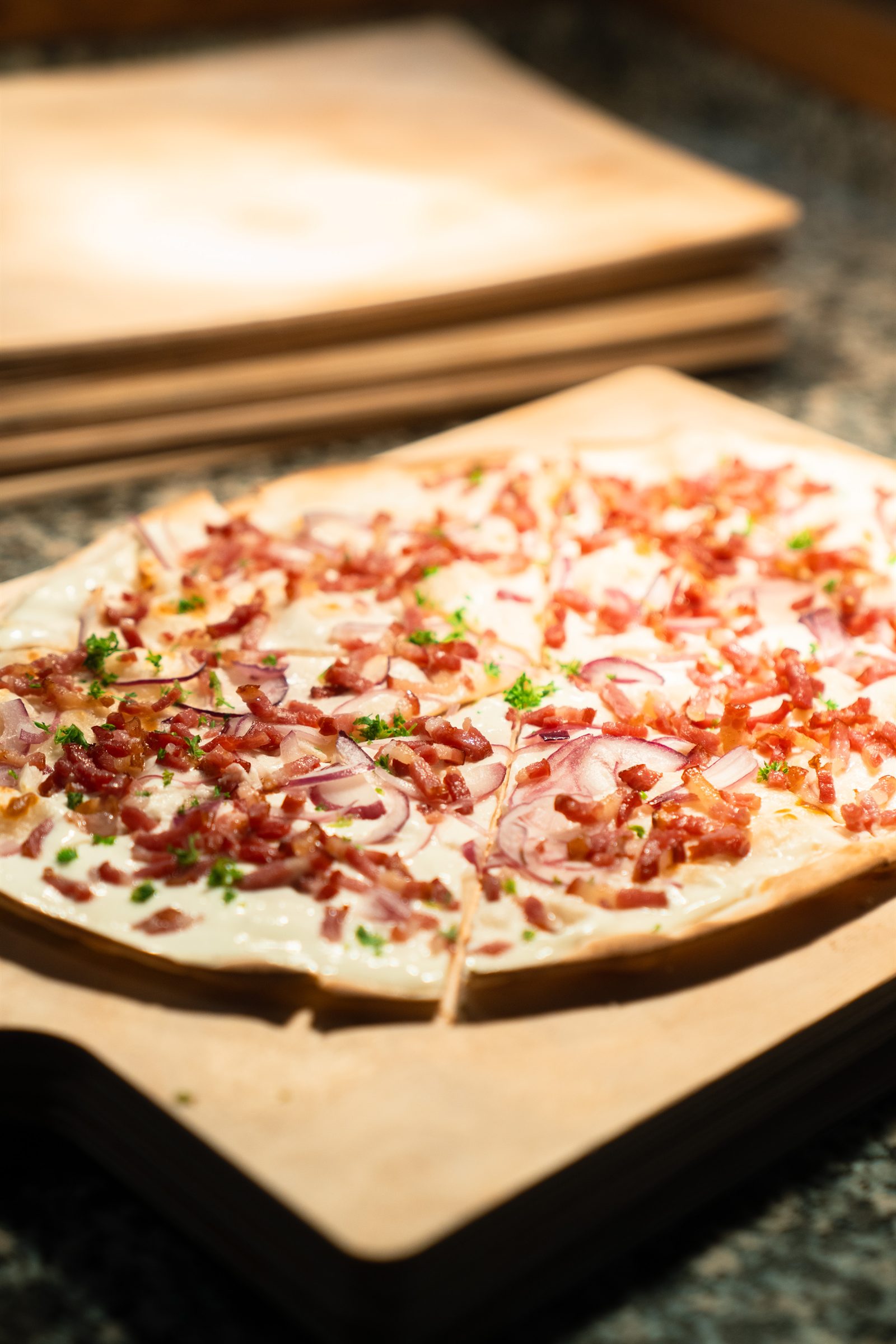 Flammkuchen with crème fraîche, bacon and red onion