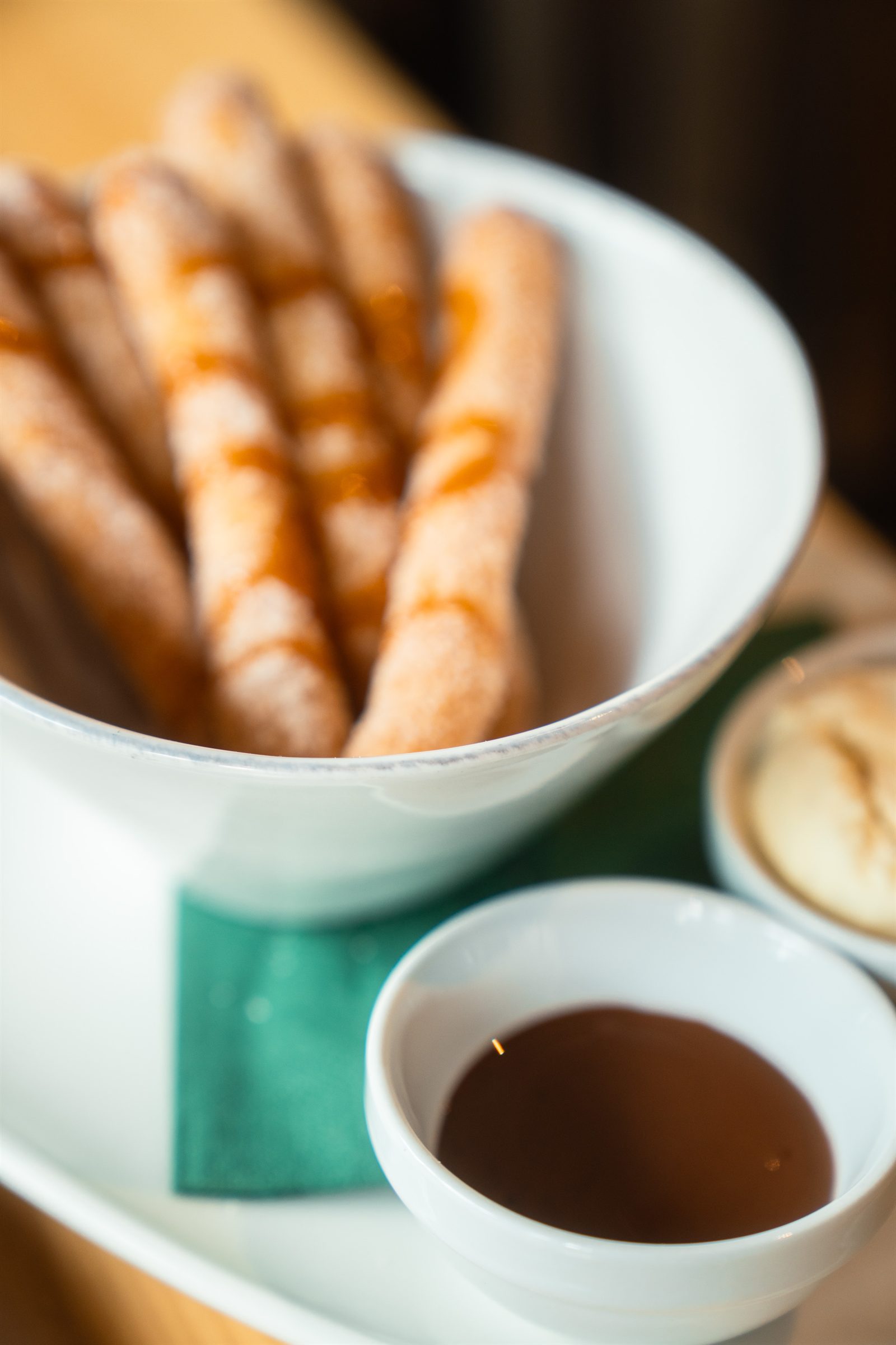 Churros with chocolate and caramel for dipping, with a coffee